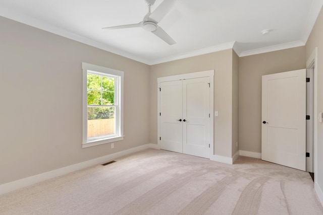 unfurnished bedroom featuring light carpet, a closet, ceiling fan, and ornamental molding