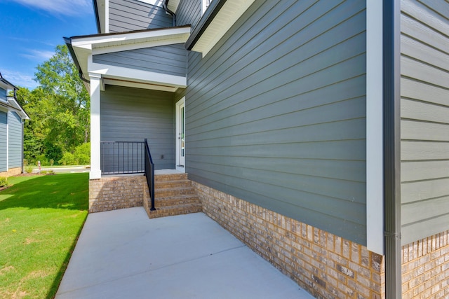 property entrance featuring brick siding and a yard