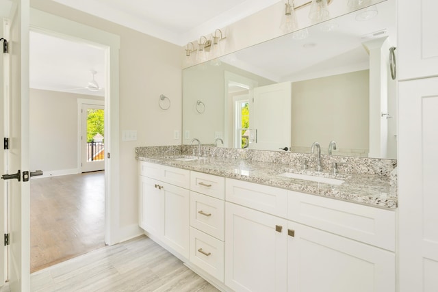 bathroom with ceiling fan, vanity, wood-type flooring, and ornamental molding