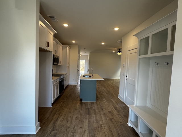 kitchen featuring sink, a breakfast bar area, white cabinetry, a center island with sink, and stainless steel appliances