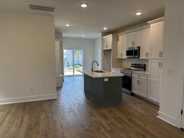 kitchen featuring white cabinetry, stainless steel appliances, sink, and a center island with sink