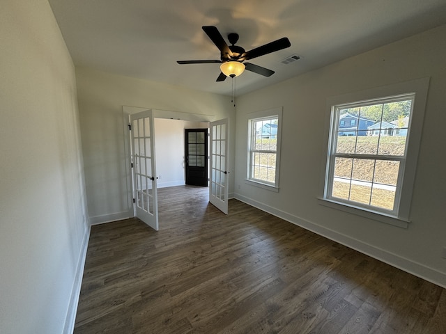 empty room with french doors, ceiling fan, and dark wood-type flooring