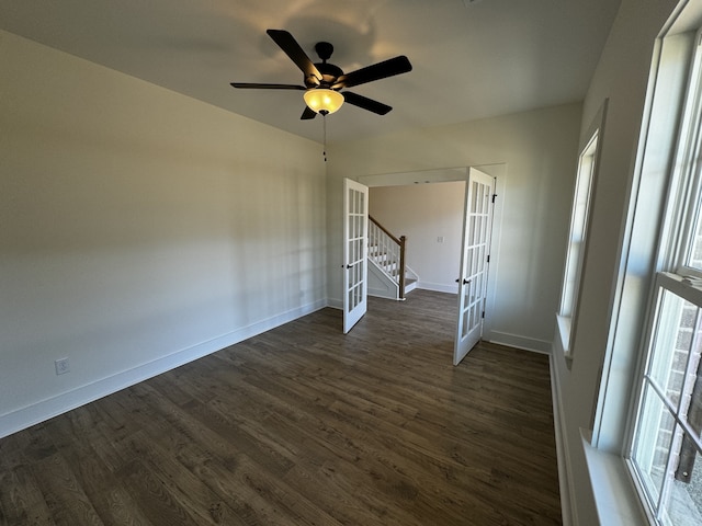 unfurnished room featuring a healthy amount of sunlight, dark hardwood / wood-style floors, ceiling fan, and french doors