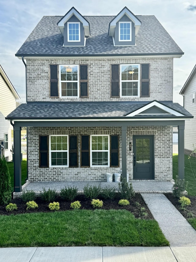 view of front facade featuring a front yard and covered porch