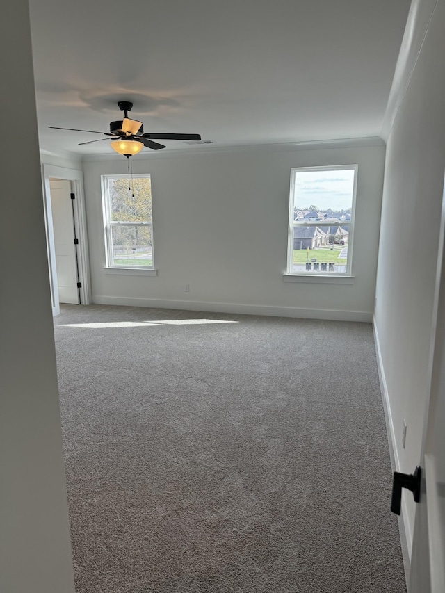 empty room with crown molding, light colored carpet, and ceiling fan