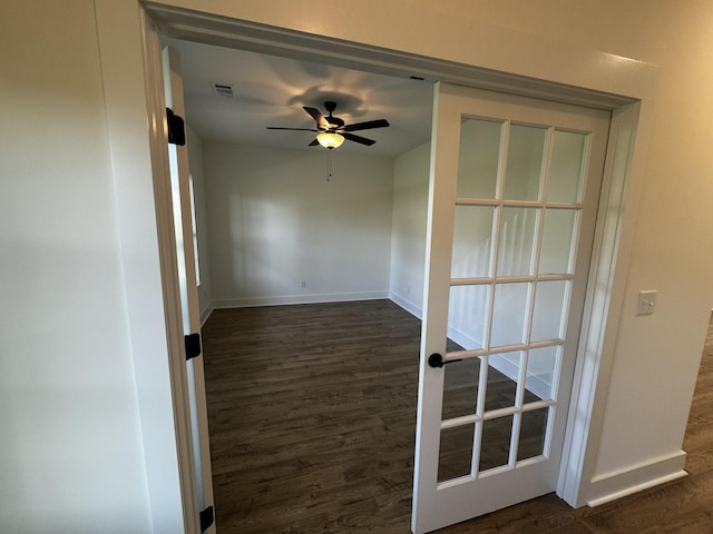 empty room with french doors, ceiling fan, and dark hardwood / wood-style flooring