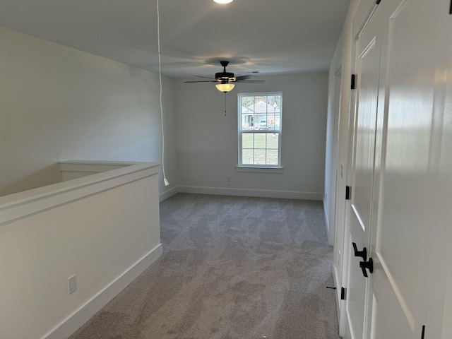 spare room featuring ceiling fan and light carpet