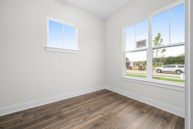 spare room with dark wood-type flooring and baseboards