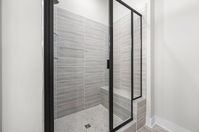 full bath featuring a stall shower and baseboards