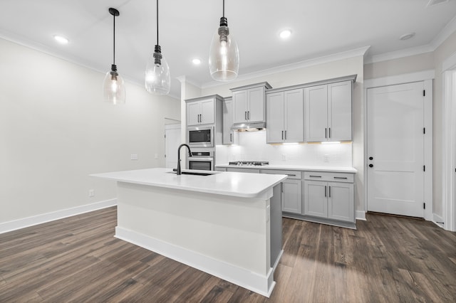 kitchen with dark wood-style flooring, gray cabinets, ornamental molding, under cabinet range hood, and appliances with stainless steel finishes