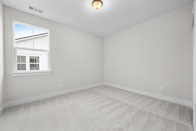 carpeted spare room featuring visible vents and baseboards