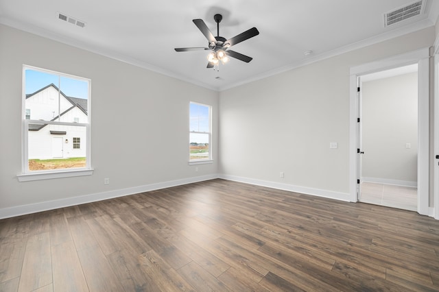 empty room featuring visible vents, dark wood finished floors, and crown molding