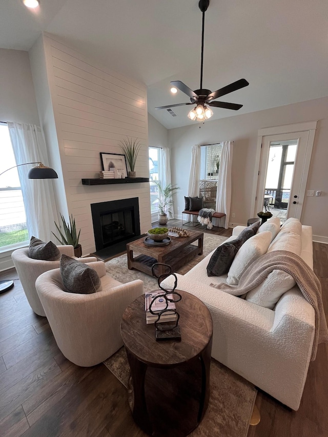 living area with lofted ceiling, a healthy amount of sunlight, and wood finished floors