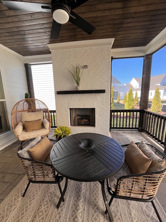 balcony with an outdoor living space with a fireplace and a ceiling fan