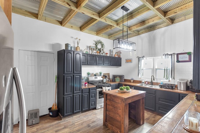 kitchen featuring sink, hanging light fixtures, light hardwood / wood-style floors, gray cabinets, and appliances with stainless steel finishes