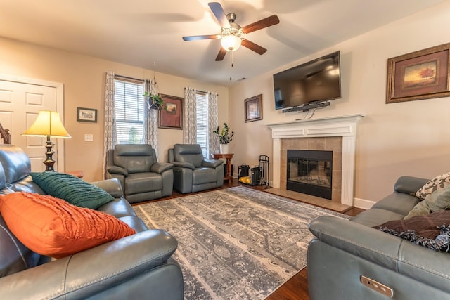 living room with a tiled fireplace, ceiling fan, and hardwood / wood-style floors