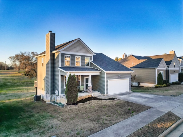 view of front of home featuring a porch, a garage, and a front lawn