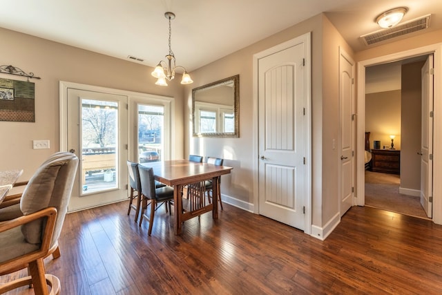 dining room featuring dark hardwood / wood-style floors and an inviting chandelier