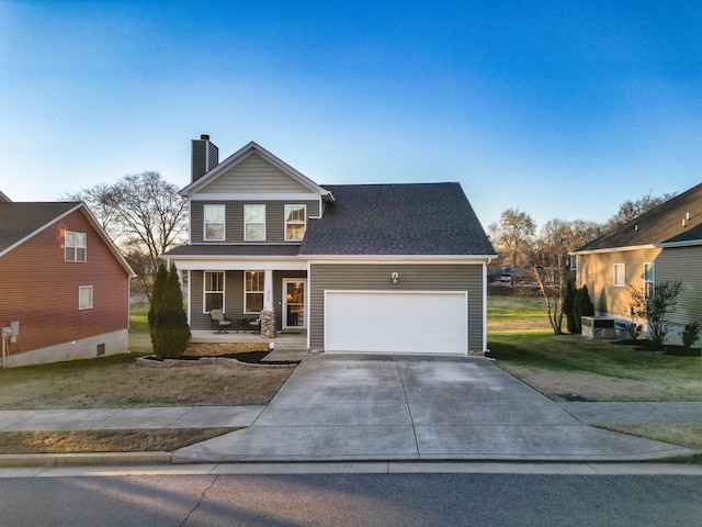 view of front of house featuring a garage, covered porch, and a front yard