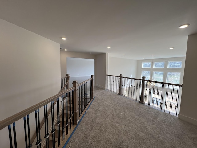 hallway featuring an upstairs landing, baseboards, carpet flooring, and recessed lighting