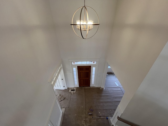 foyer entrance with a chandelier and a high ceiling