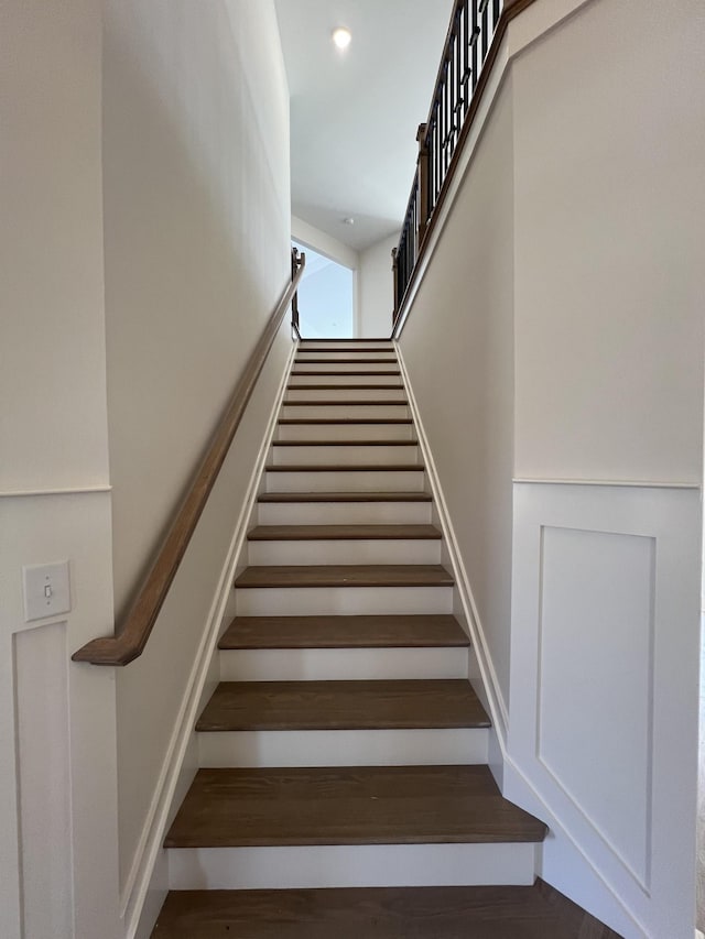 stairs featuring a towering ceiling and recessed lighting