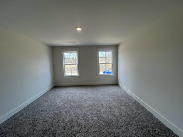 carpeted empty room featuring visible vents and baseboards