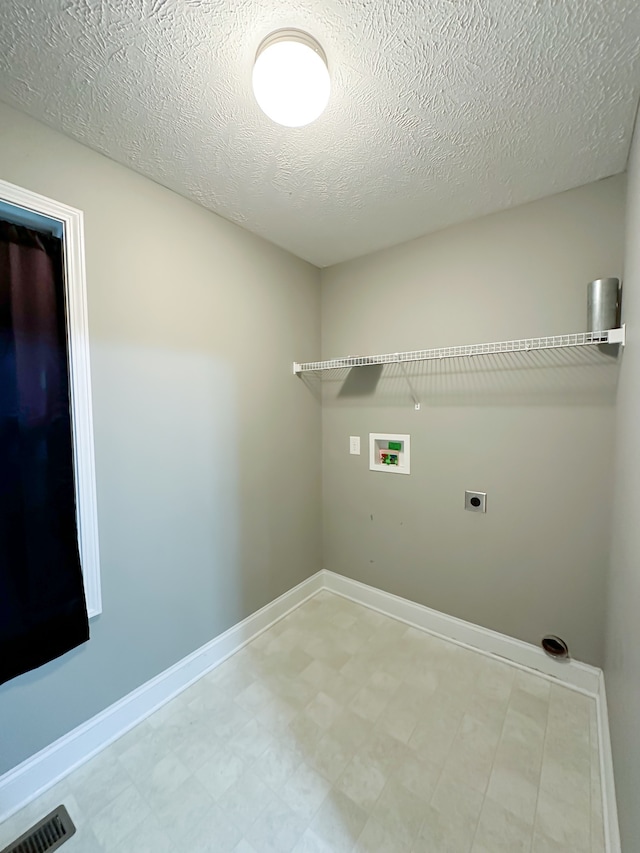 clothes washing area featuring electric dryer hookup, hookup for a washing machine, and a textured ceiling