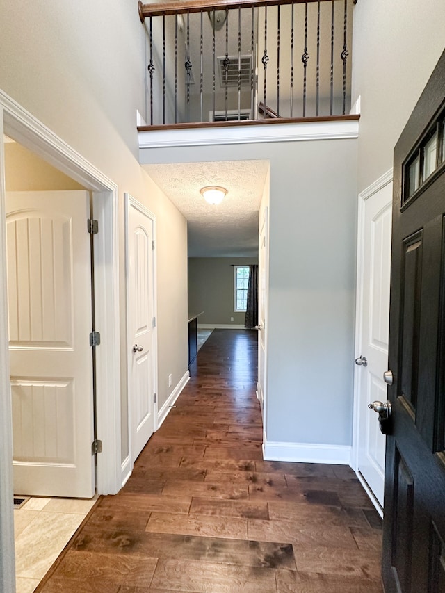 entryway with dark wood-type flooring and a textured ceiling