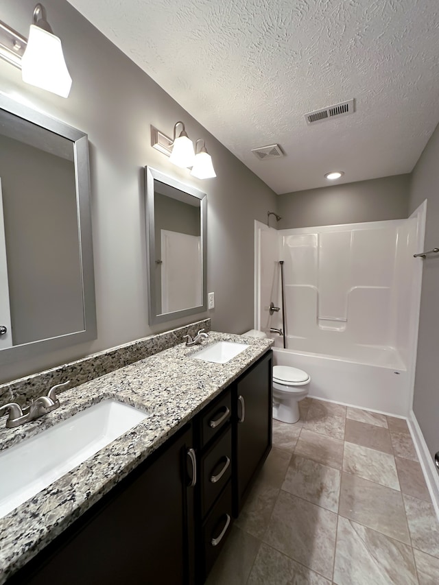 full bathroom with vanity, a textured ceiling, toilet, and tub / shower combination