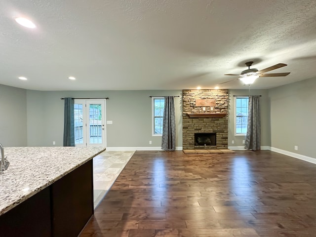 unfurnished living room with ceiling fan, dark hardwood / wood-style flooring, and a wealth of natural light