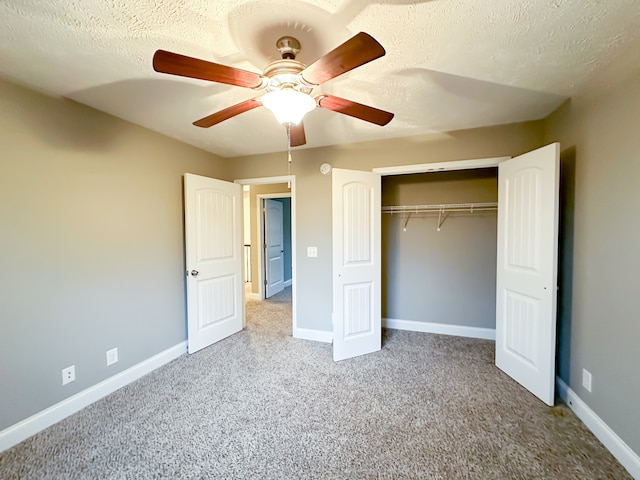 unfurnished bedroom featuring carpet, a textured ceiling, a closet, and ceiling fan