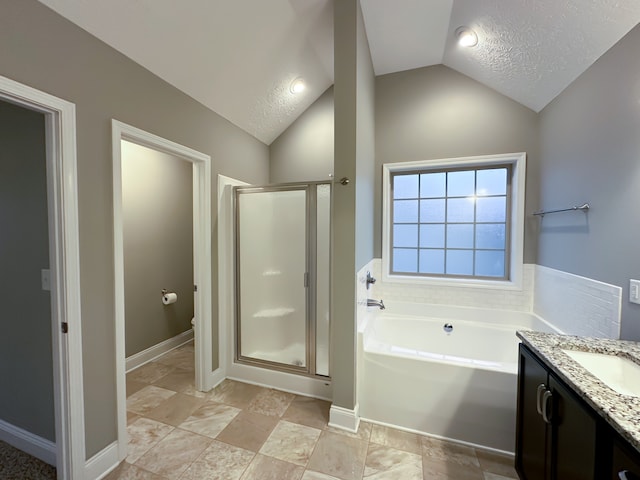 bathroom with a textured ceiling, separate shower and tub, vanity, and lofted ceiling