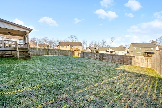 view of yard with ceiling fan and a deck