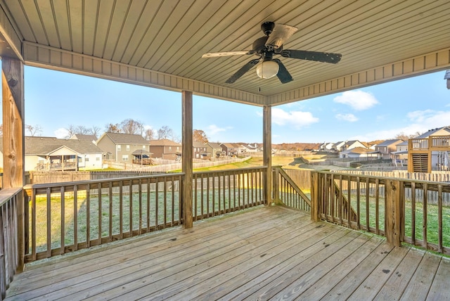 wooden deck with a lawn and ceiling fan