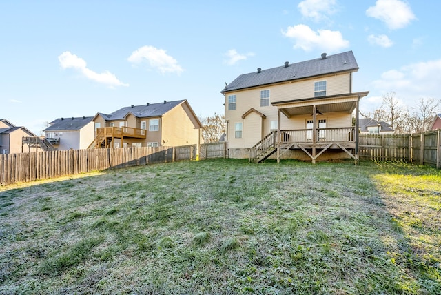 rear view of property with ceiling fan, a lawn, and a wooden deck