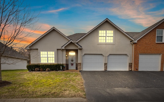 view of front of house featuring a garage and a lawn