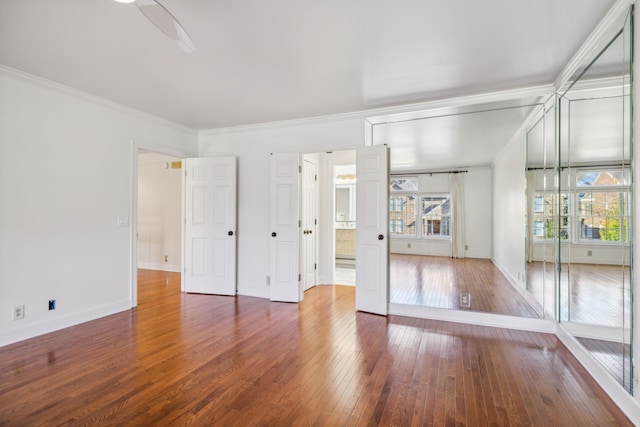 unfurnished room featuring dark hardwood / wood-style floors, ceiling fan, and crown molding