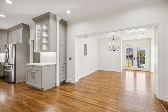 kitchen with gray cabinetry, wood-type flooring, and stainless steel refrigerator