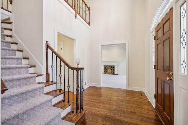 entryway with a towering ceiling, a healthy amount of sunlight, and dark hardwood / wood-style floors