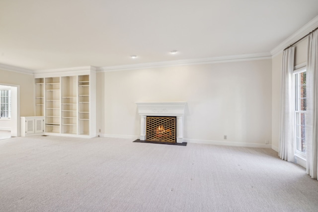 unfurnished living room featuring light carpet, a wealth of natural light, and ornamental molding