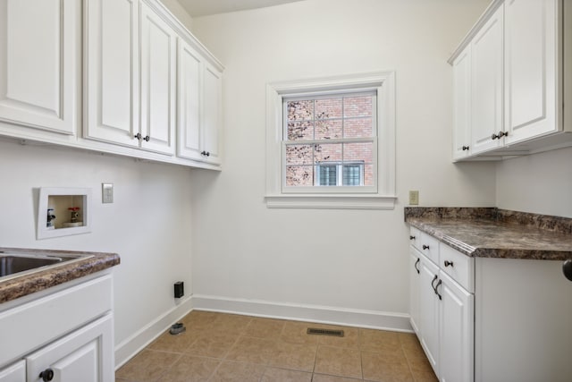 laundry area with washer hookup, cabinets, and light tile patterned floors