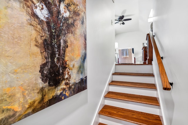 stairs featuring ceiling fan