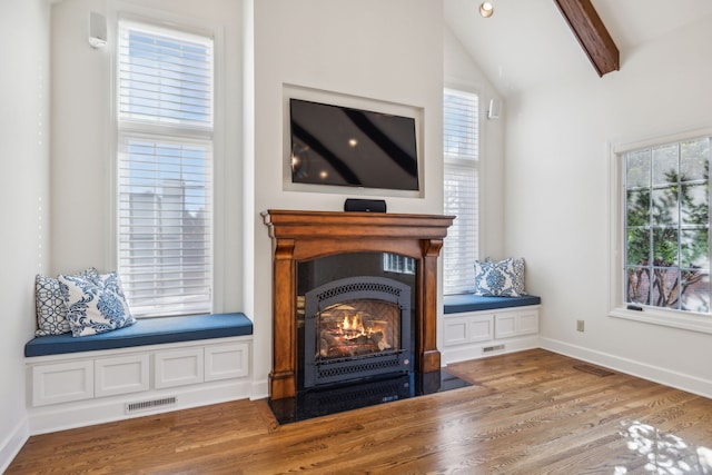 living room featuring hardwood / wood-style floors, lofted ceiling with beams, and a wealth of natural light