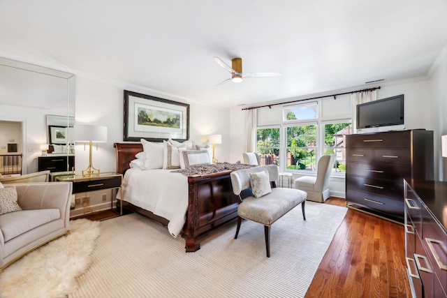 bedroom featuring ceiling fan, wood-type flooring, and ornamental molding