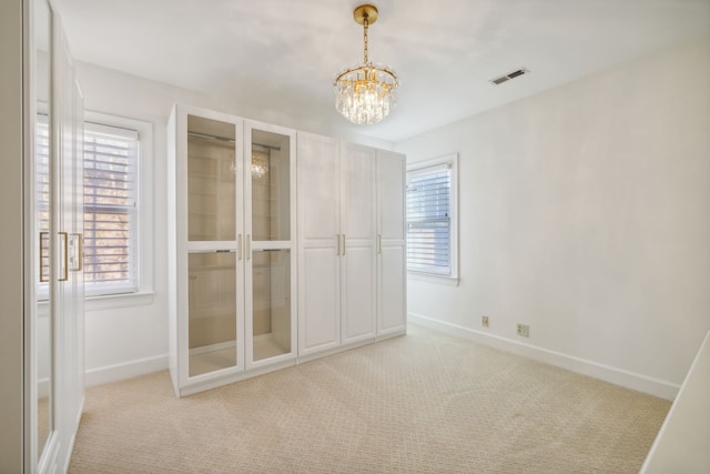 interior space with light colored carpet and an inviting chandelier