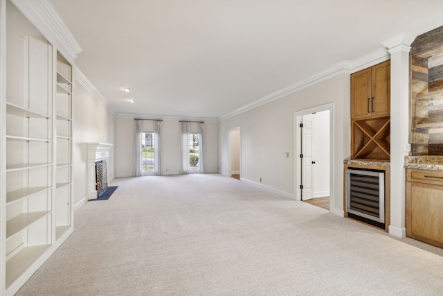 unfurnished living room with light colored carpet, ornamental molding, and wine cooler