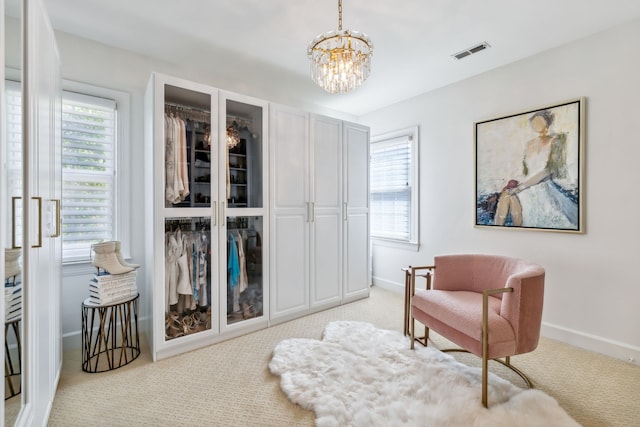 living area featuring light carpet and an inviting chandelier