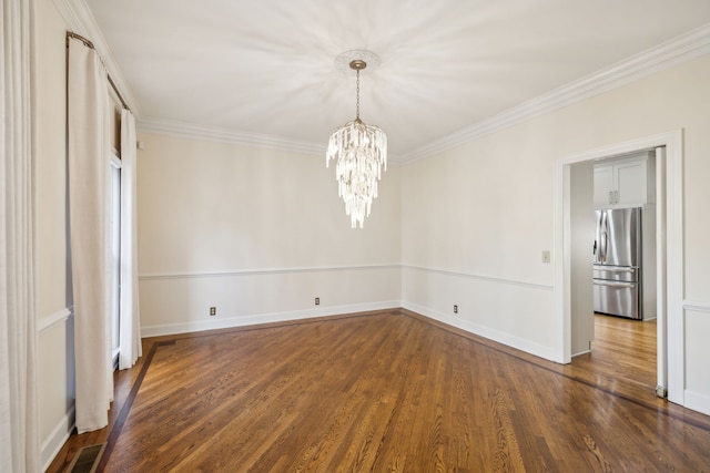 spare room with ornamental molding, dark hardwood / wood-style floors, and a notable chandelier