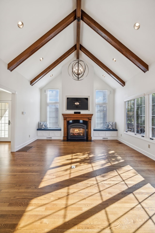 living room with beam ceiling, wood-type flooring, high vaulted ceiling, and an inviting chandelier